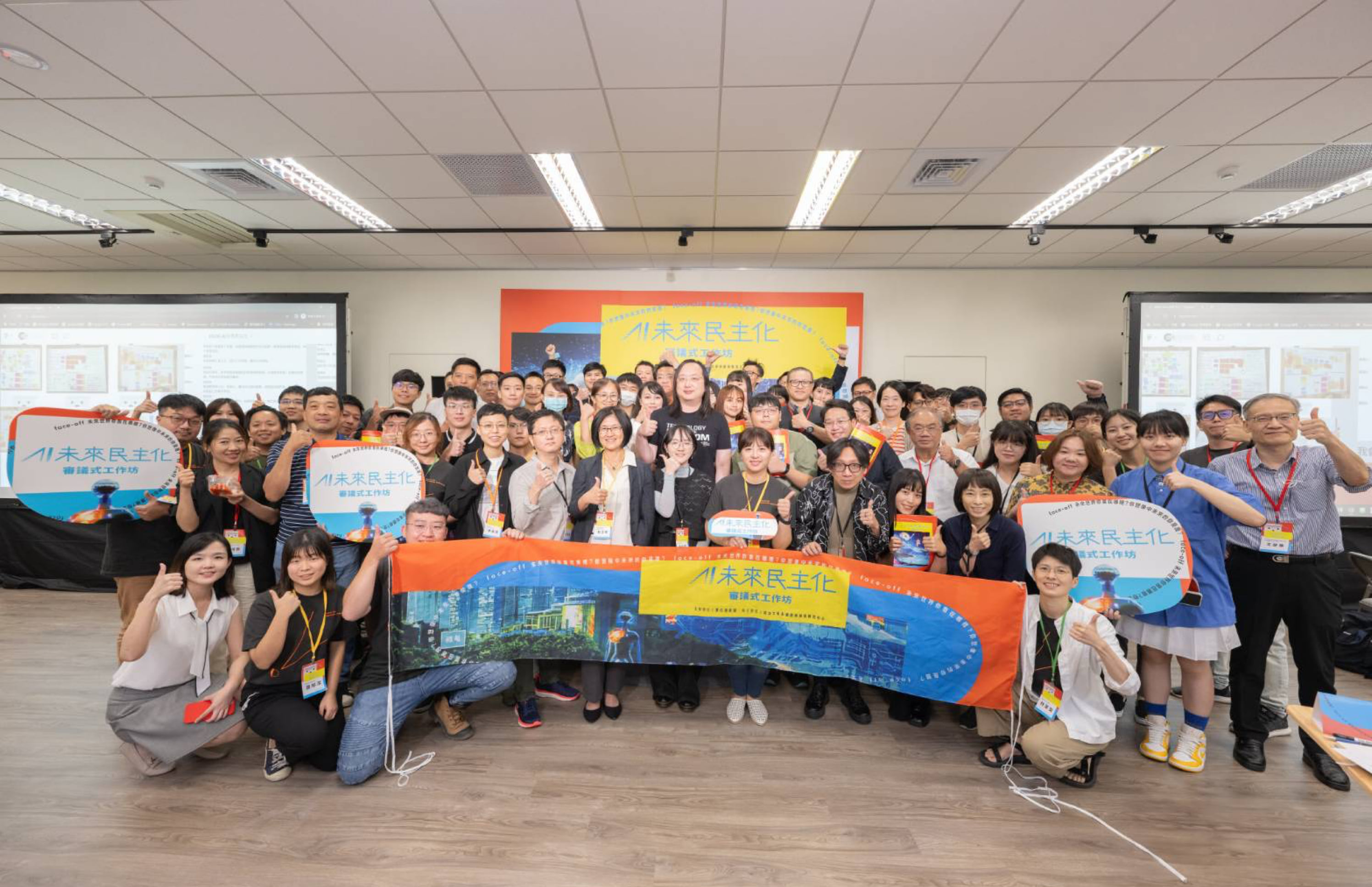 Group photo of participants in Taiwan's citizens' deliberation on deepfake scam ads, holding banners